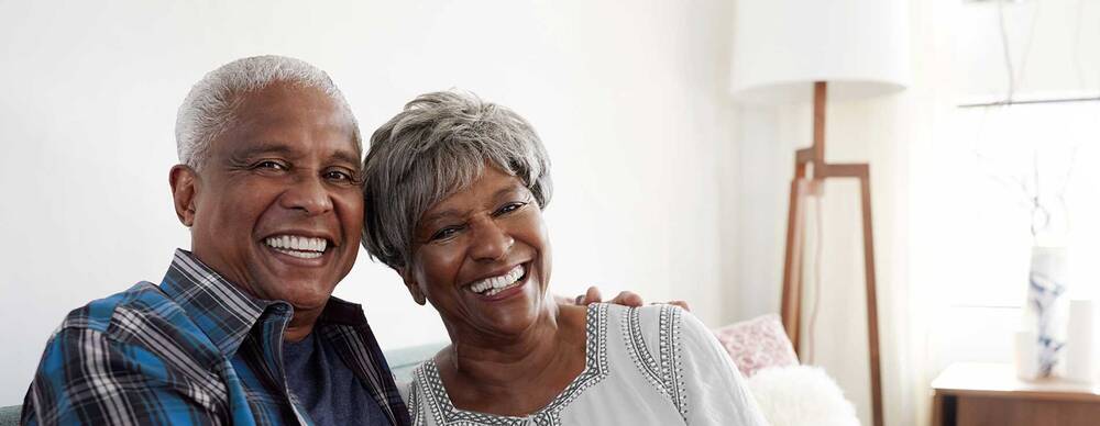 Elderly couple smiling on couch