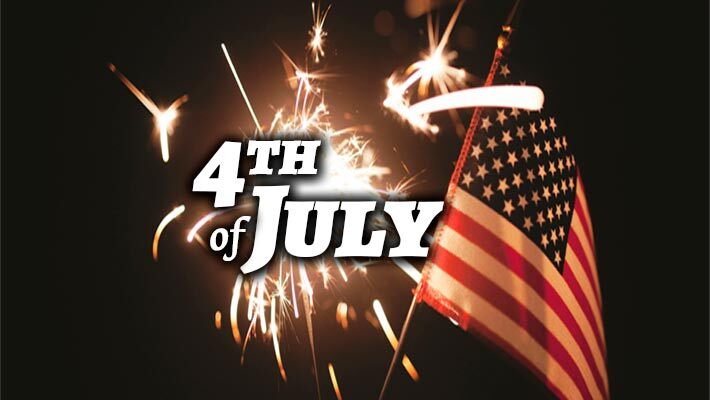 4th of July. A sparkler and an small American flag are being held up in the dark.