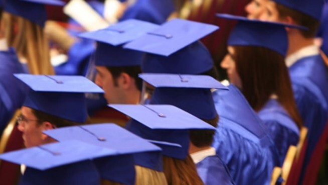 Graduation caps on students sitting at commencement. 
