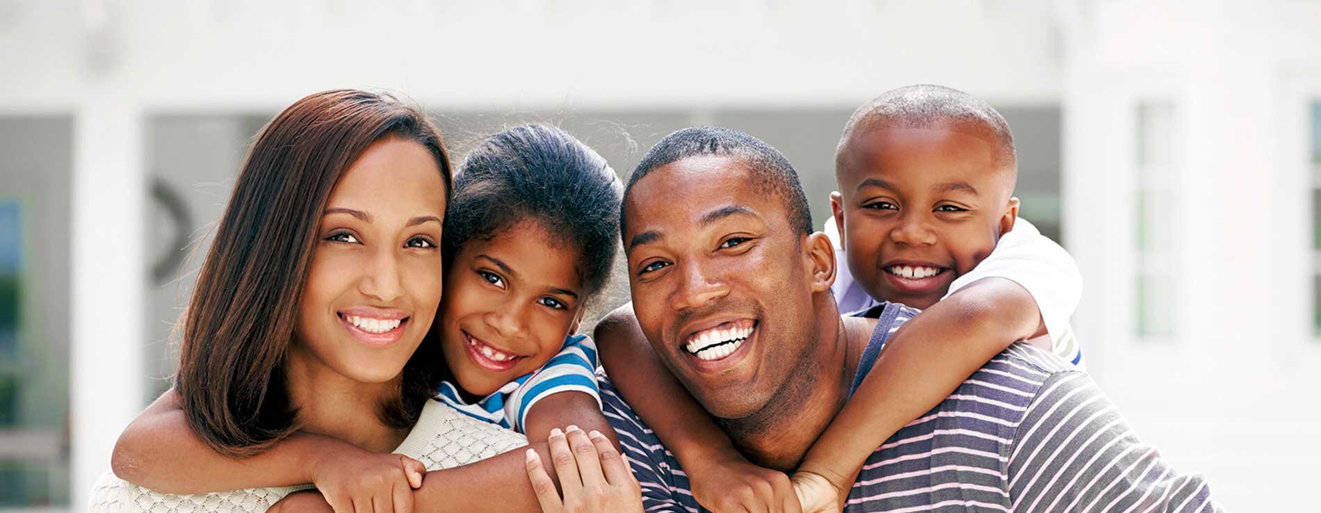 2 adults and 2 children smiling